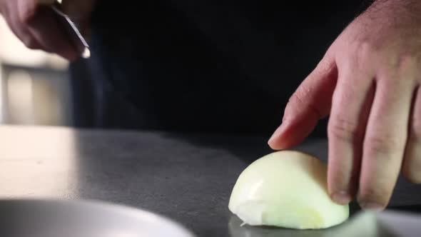 Professional chef cuts the onion 