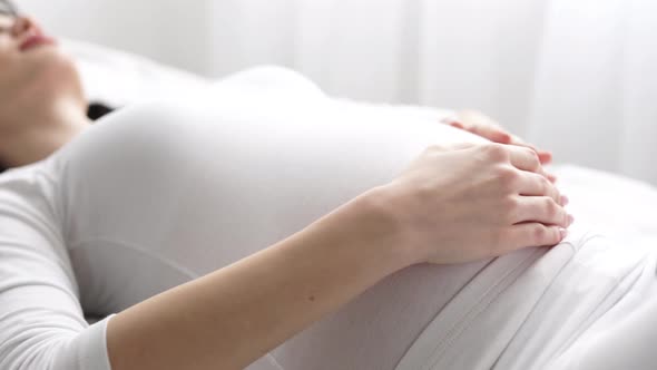 Pregnant Woman Touching Baby Belly Closeup alt