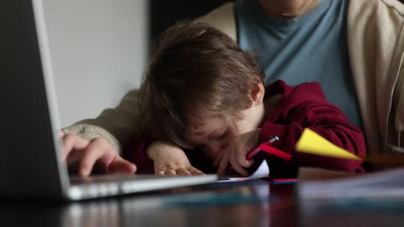 Little boy play with pencils while mother is working at home alt