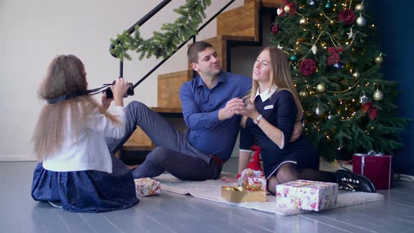 Girl Taking Pictures of Her Happy Parents at Xmas alt
