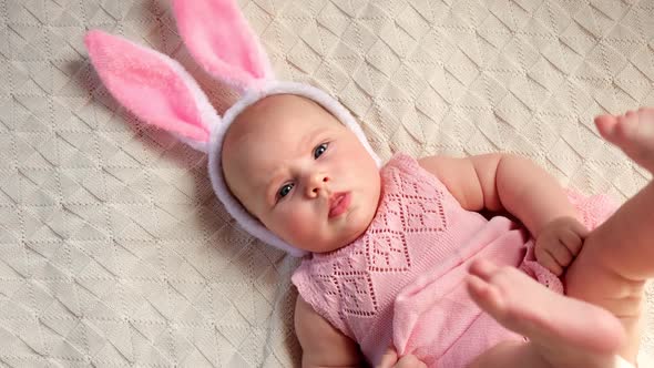 Funny Little Child is Wearing Bunny Ears Smiling and Looking to the Camera alt