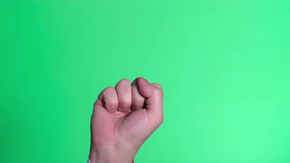 Male Hand Clenched on a Green Background of the Color Key Screen alt