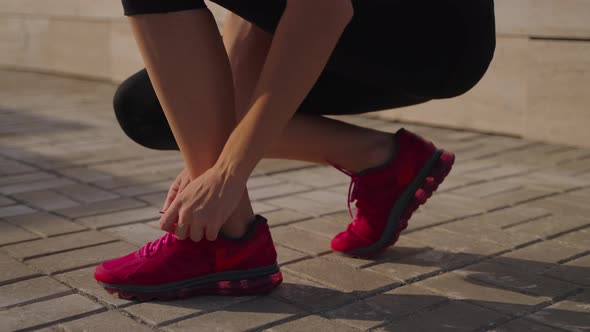 Woman Tying Laces on Sports Shoes Before Training alt
