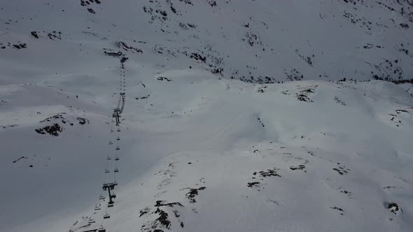 Snowy Mountain Skilifts and Furniculars and Skislopes in Austrian Alps Drone Flyover the Mountains