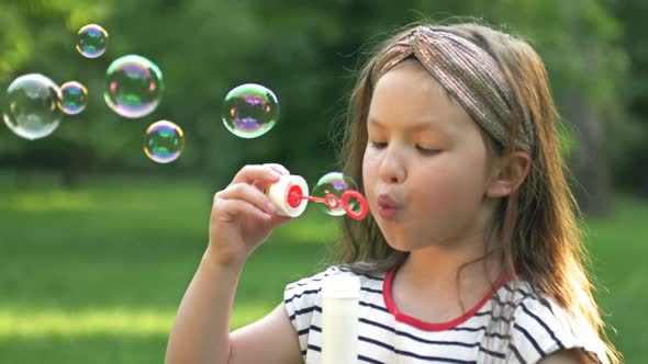 Funny Toothless Preschool Girl Enthusiastically Blowing Soap Bubbles