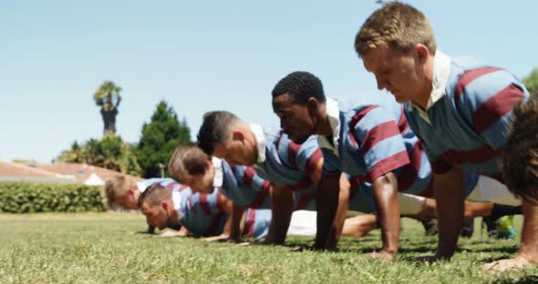 Rugby players doing push ups in the field 4K alt