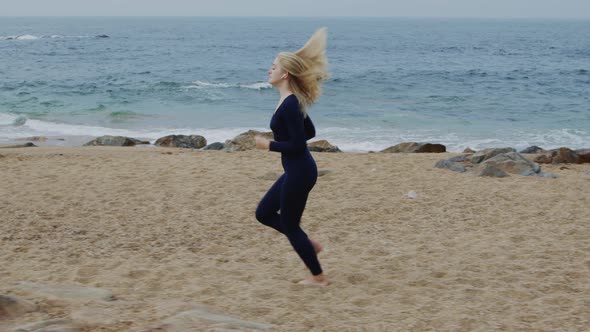 Fit Woman Is Running On Beach