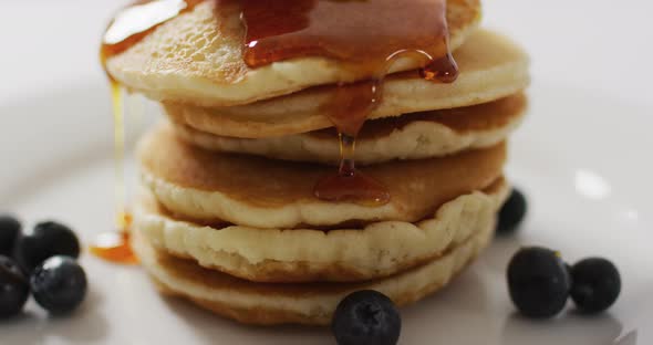 Video of pancakes on plate seen from above on white background alt