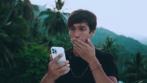 Shocked Young Man Traveler Using Smartphone Loses Dissatisfied with Bad News Outdoors alt