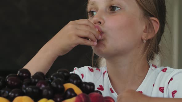 Little Girl Eats an Apricot