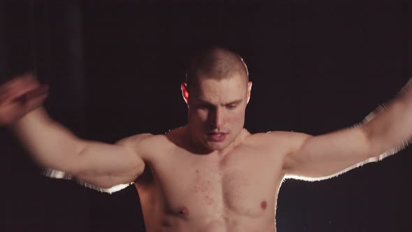 Young Good Looking Pumpedup Guy in Denim Shorts Warming Up His Hands with Wrists and Looking in the alt