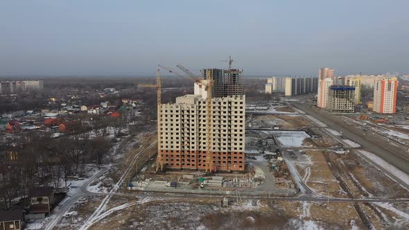 Construction of a Large Apartment Building. Tower Cranes and Builders Build a Brick House View From