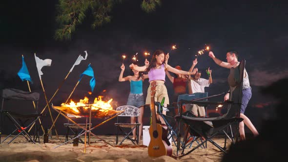Group of Asian young man and woman having party on the beach at night. alt