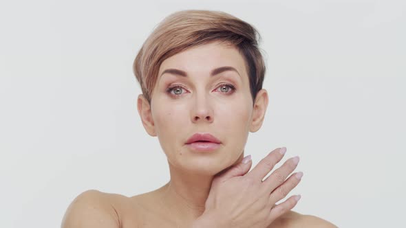 Close-up of middle aged mature woman over white background. alt