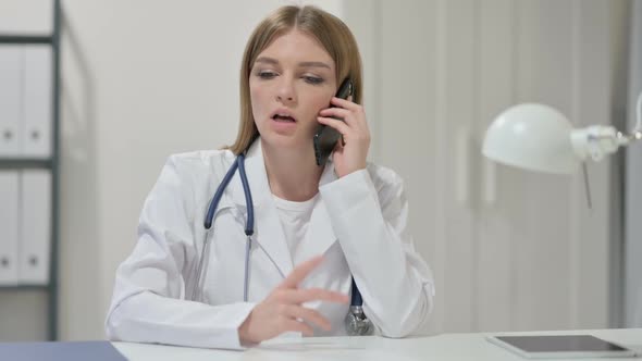 Female Doctor Talking on Smartphone at Work alt