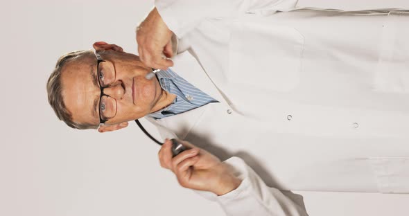 Mature Professional Experienced Pediatric Specialist Dressed in a Shirt White Apron and Glasses Puts alt