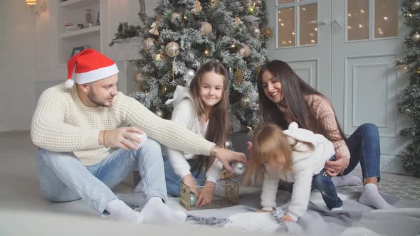Parent and Two Little Children Having Fun and Playing Together Near Christmas Tree Indoors alt
