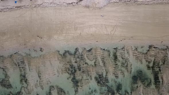 Locals on mysterious beach ebb tideSpectacular aerial view flight bird's eye view drone footage of alt