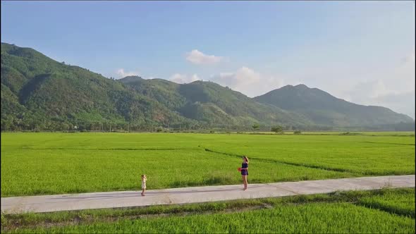 Aerial View Mom and Little Girl Play with Red Ball on Road alt