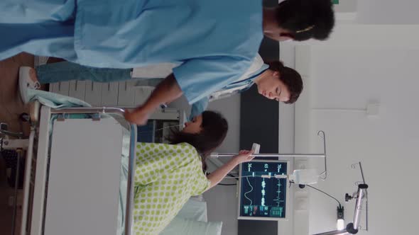 Vertical Video Medical Team Checking Patient Vital Monitoring Heart Rate Helping with Fluids Drip alt