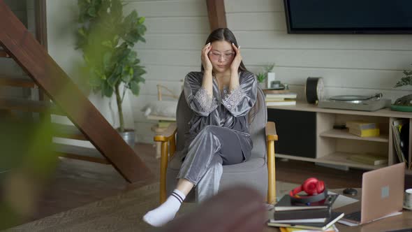 Wide Shot of Tired Overwhelmed Young Asian Woman Taking Off Eyeglasses Stretching Neck Rubbing alt