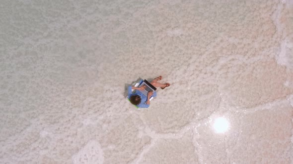Woman Freelancer Works at a Laptop on the Shores of the Dead Sea in Israel alt