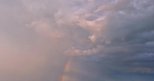 During a Severe Thunderstorm in a Landscape a Bright Rainbow Can Be Seen in the Sky alt