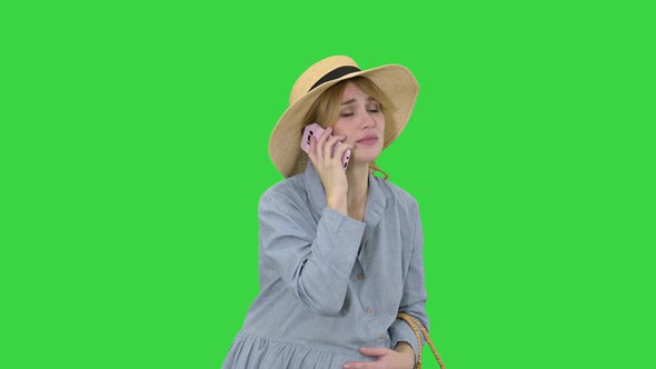 Worried Pregnant Woman Talking on the Phone Having Contractions on a Green Screen, Chroma Key. alt