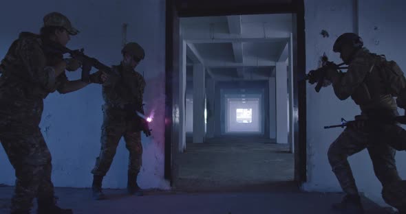 Masked Team of Armed Modern Warfare Soldiers Team Move in Tactical Formation in a Dark Urban alt