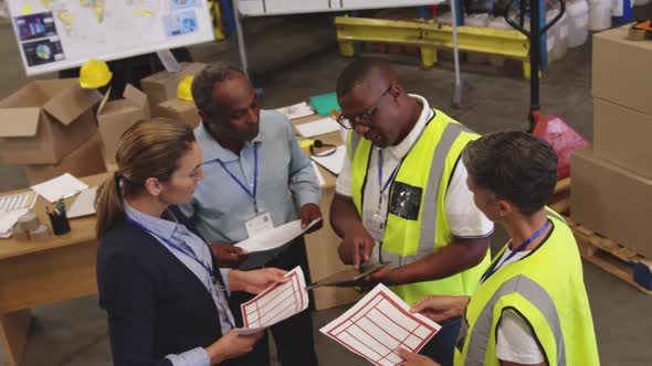 Warehouse staff with documents talking 4k alt