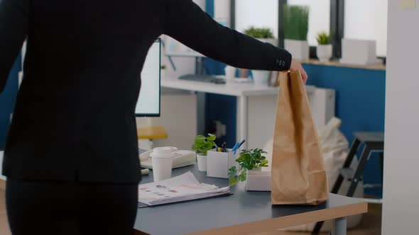 Cheerful Businesswoman Putting Food Takeaway Order Package on Desk Table During Lunchtime Break alt