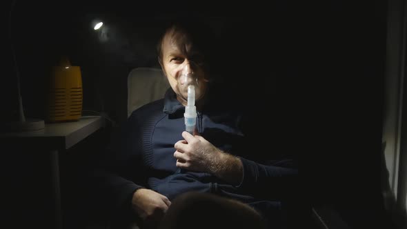 a Middleaged Man Breathes Medications for Bronchitis at Night Through a Nebulizer