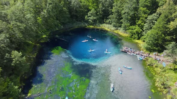 Diver whips fountain of splashes with his fins. Sup float slowly along the lake. alt