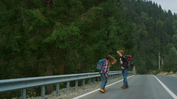 Dancing Lovers Walk Hitchhike on Forest Roadside alt