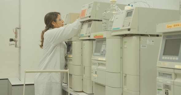 Scientist working with mass spectrometer in a pharmaceutical laboratory conducting experiments alt