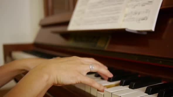 Hobby female pianist playing a melodic piece on antique vintage 100 year old piano alt
