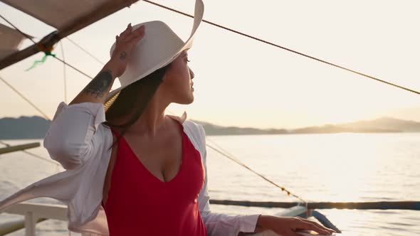 Woman Relaxing On Outrigger Boat In Sun Hat alt