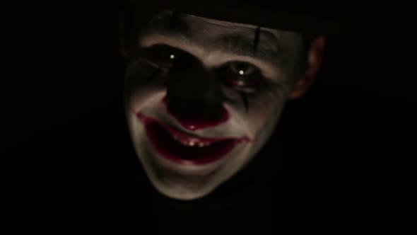 Terrible Clown Looks at the Camera and Laughs Terribly