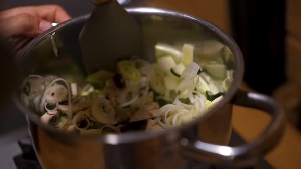 Sauteing zucchini courgette and mushrooms on a pan in slow motion alt