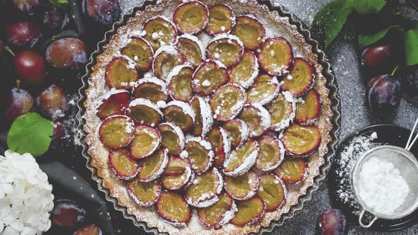 Homemade Delicious Plum Tart with with Sugar Powder Placed on the Table