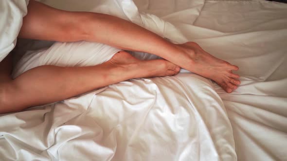 Beautiful Female Legs Gracefully Move in Bed in the Morning alt