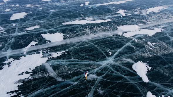 Aerial View of Man Skating on Lake Baikal Covered By Ice alt