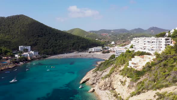 Aerial footage of the Spanish island of Ibiza showing the beautiful beach front alt