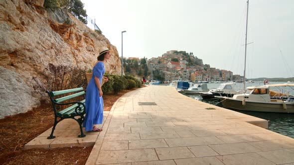Attractive traveler on the pier in Sibenik, Croatia. Slow motion video alt