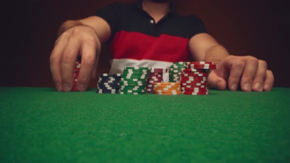 Male Player Moving Casino Chips on Poker Table Close Up