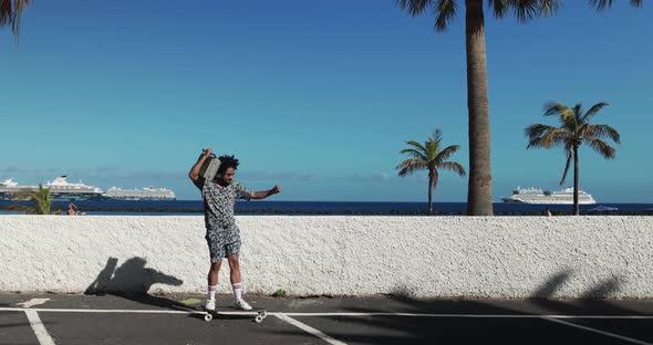 Young african american man riding longboard outdoor holding vintage boombox alt