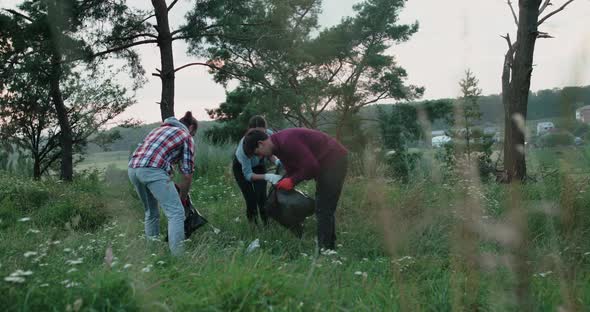 Happy Girl and Men Cleaning the Nature From Plastic with Smile on Faces alt