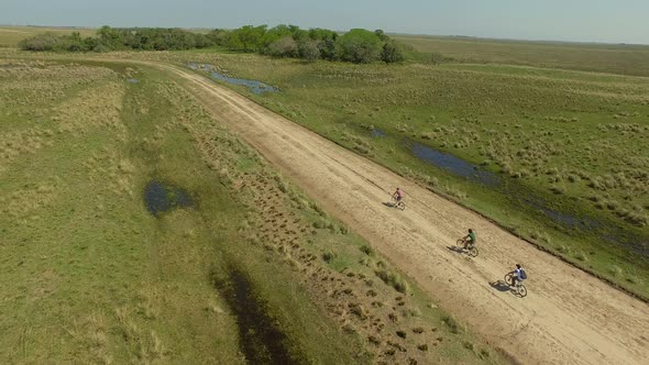 Aerial view of cyclists on dirt road, Ibera Wetlands, Corrientes Province, Argentina alt