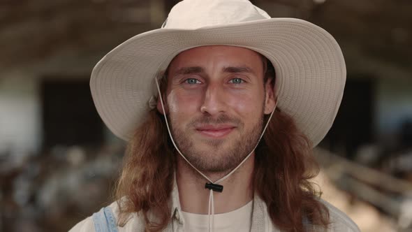 Smiling Caucasian Man in Hat Posing at Goat Farm alt