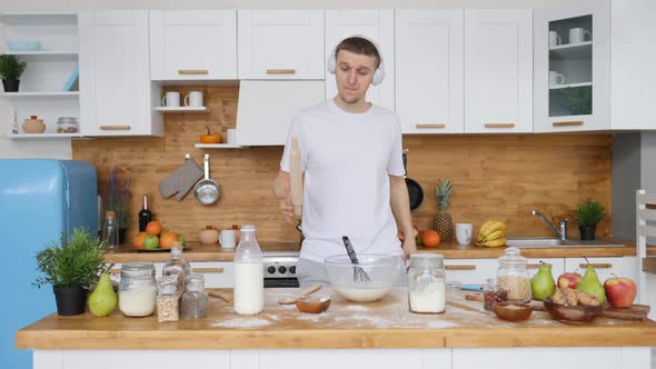 Man Dancing In Headphones While Cooking Breakfast In Kitchen alt